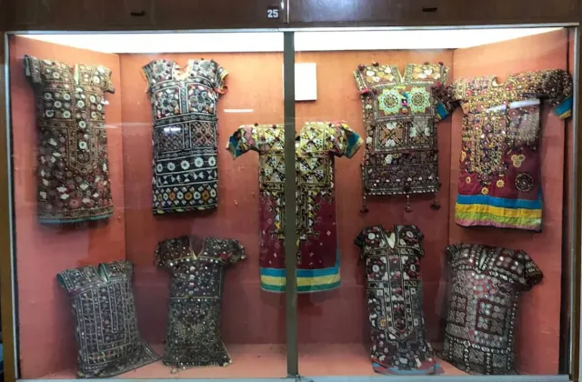 Traditional Sindhi women's tunics with gaj panels embroidered by hand displayed in a museum